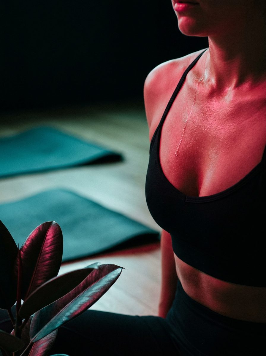 A bead of sweat on a collarbone in red light